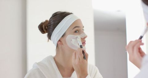 Woman Applying Facial Mask in Bathroom for Skincare Routine