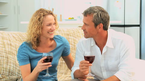 Couple Enjoying Red Wine Together on Cozy Sofa
