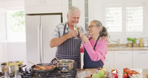 Senior Couple Preparing Meal and Toasting in Modern Kitchen