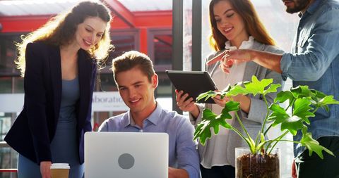 Collaborative Team Engaging with Technology in Modern Office