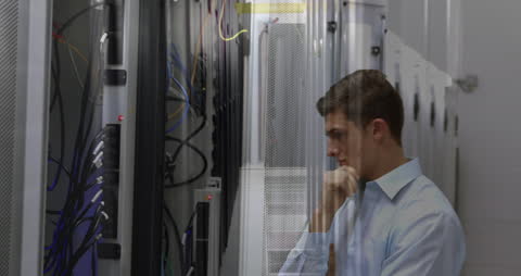 Young Professional Analyzing Data in Server Room