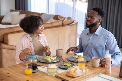 Happy Couple Enjoying Breakfast with Avocado Toast and Coffee at Home