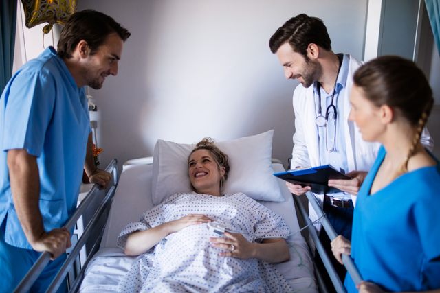 Doctors are interacting with a pregnant woman who is lying in a hospital bed. The scene depicts a positive and supportive healthcare environment. This image can be used for healthcare-related content, maternity services, medical consultations, and hospital promotional materials.