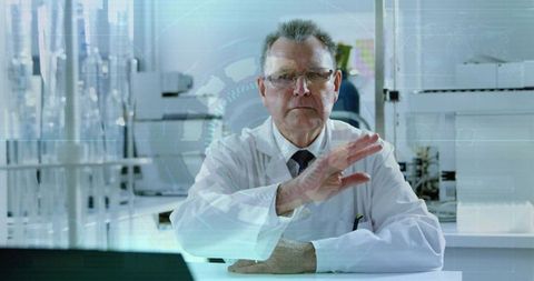 Senior scientist interacting with holographic interface at laboratory bench for digital research