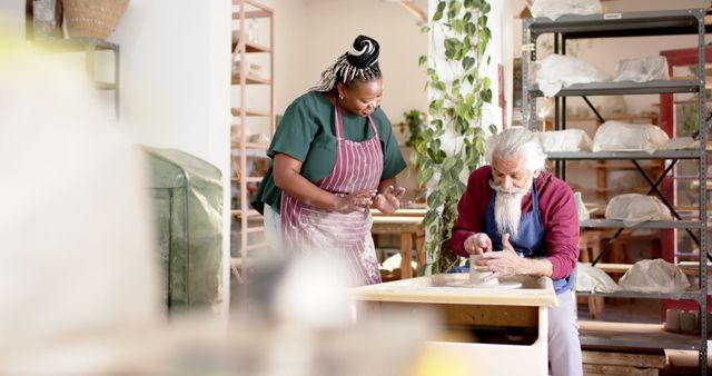 Elderly man and woman together creating pottery in an art studio atmosphere. Shelves with pottery pieces are visible in the background. Ideal for depicting crafts, arts education, intergenerational activities, and cultural exchange themes.