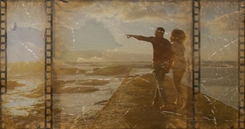 Couple gazing at sunset on coastal jetty with vintage film aesthetic
