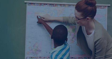 Teacher Helping Student Understand World Geography in Classroom