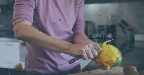 Closeup woman peeling ripe mango with paring knife on cutting board in modern home kitchen