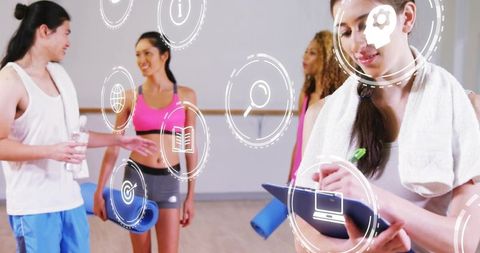 Fitness instructor coaching group class in studio with digital hud overlays and clipboard