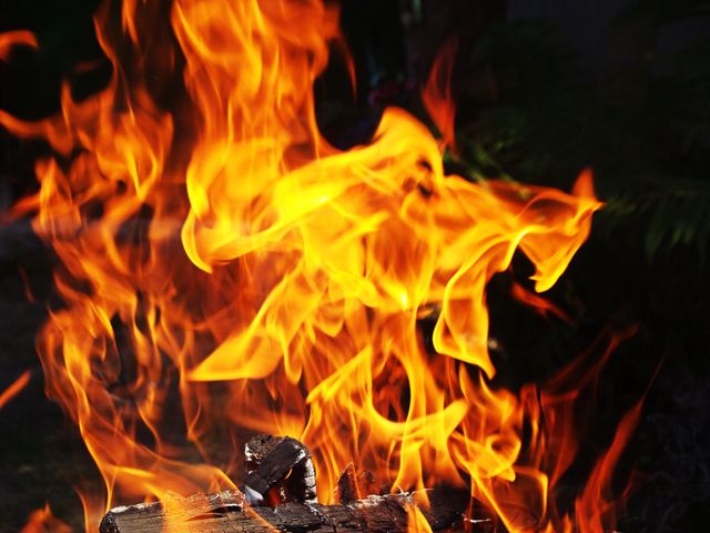 Close-up view of bright, intense flames rising from burning logs, showcasing the energy and heat of a strong fire. Useful for depicting fire safety concepts, outdoor activities, camping scenes, or illustrating stories involving fire.