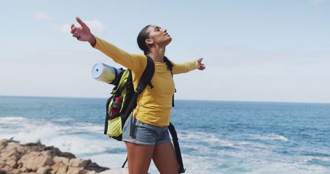 Woman Hiking with Open Arms near Ocean
