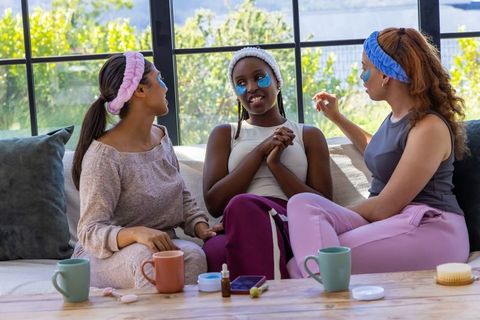 African american women enjoying at-home spa night with under-eye patches and cozy tea