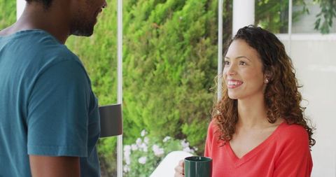 Joyful Woman Enjoying Coffee with Partner on Sunny Patio