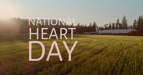 text celebrating national heart day appears over a lush green field at golden hour, enhanced by silhouettes of distant trees. this suggests themes of health, heart awareness, and connection with nature. perfect for campaigns promoting heart health, environmental wellness, or nature-themed events. can be used in digital or print media focusing on health observance or celebrating environmental beauty.