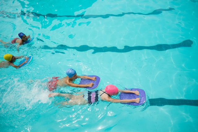 Children using kickboards in a swimming pool, engaging in a swim class or training session. Ideal for illustrating swim lessons, aquatic sports, children's activities, and summer recreation. Can be used for promoting swim schools, fitness programs, and water safety campaigns.