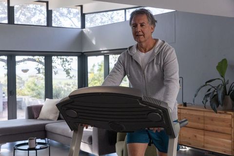 Senior Man Exercising on Treadmill in Contemporary Living Room