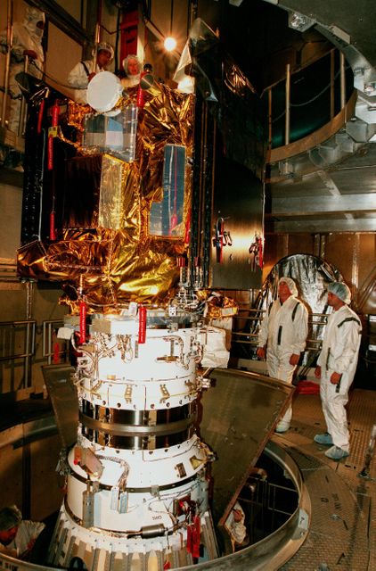 This image depicts NASA technicians preparing the Deep Space 1 spacecraft on Launch Pad 17A at Cape Canaveral Air Station. This scene showcases critical pre-launch processes involving advanced space technology. Great for content related to space exploration, NASA missions, scientific advancements in space, and technological innovations.