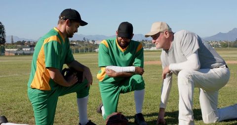 Baseball coach coaching players kneeling on field discussing game strategy and teamwork