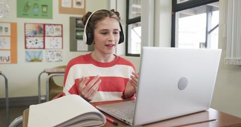 Young Girl Using Laptop with Headphones for Learning