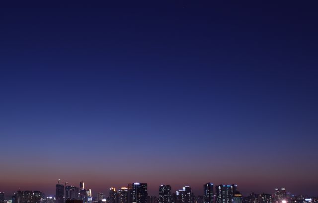 Urban cityscape with twilight gradient sky. Ideal for evening urban scenes, city life, and architectural designs. Can be used for web backgrounds, blog posts, or adverts related to city living, nightlife, or travel.