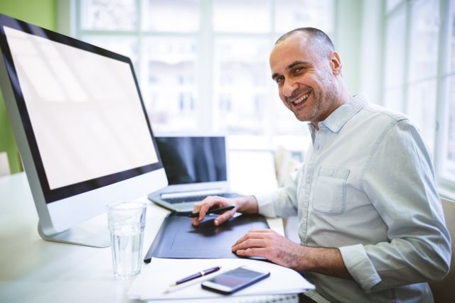 Portrait of smiling graphic designer using computer in creative office
