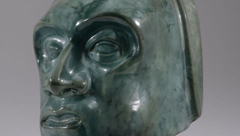 Glossy Teal Ceramic Sculpture Head Close-Up Showing Glazed Surface and Reflections