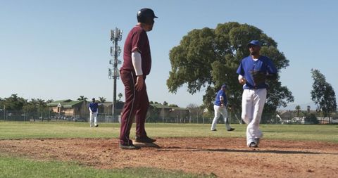 Diverse baseball players competing on sunlit field