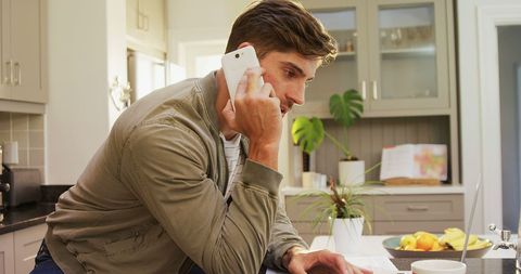 Young Man on Phone Call in Modern Kitchen Setting