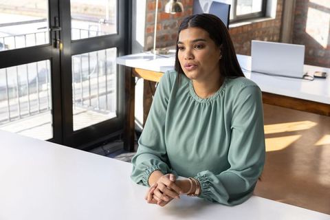 Professional woman at loft office desk contemplating projects