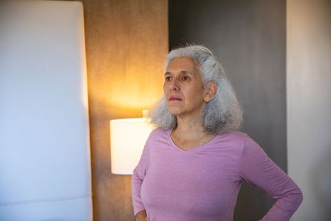 Senior Woman Displaying Confidence in Cozy Bedroom Interior