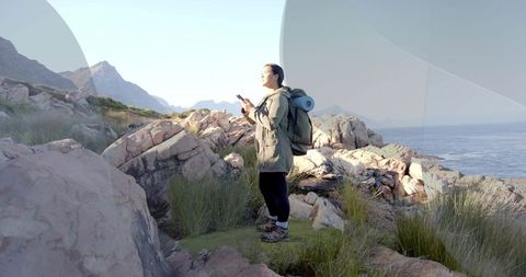 Woman Exploring Coastal Wilderness With Backpack and Phone