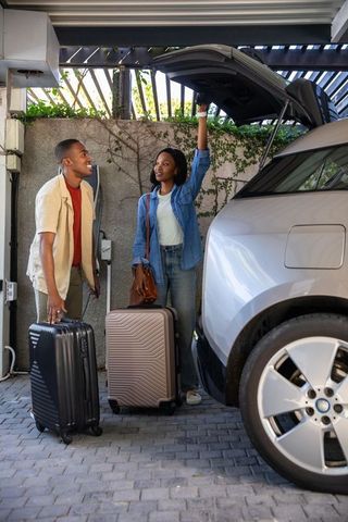 Couple Prepares for Journey by Loading Luggage in Electric Silver SUV