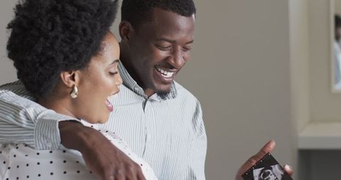 Happy Couple Viewing Cherished Photograph Showing Nostalgia and Love