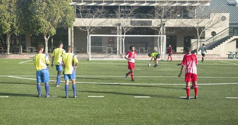 Soccer Players on School Field Practicing Penalty Kick