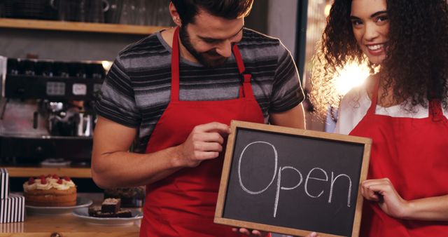 Smiling Cafe Owners Holding Open Sign in Cozy Coffee Shop - Download Free Stock Images Pikwizard.com