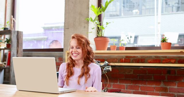 Smiling Woman Using Laptop in Modern Industrial Workspace - Download Free Stock Images Pikwizard.com