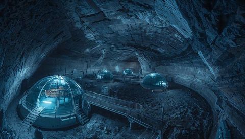 Futuristic subterranean dome habitat with glowing consoles and elevated catwalks