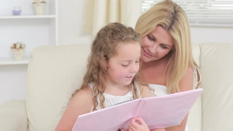 Mother and Daughter Sharing Story Time Together at Home