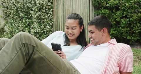 Young Couple Smiling and Relaxing While Taking Selfie on Lawn
