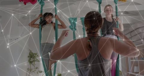 Aerial yoga class with digital network overlay