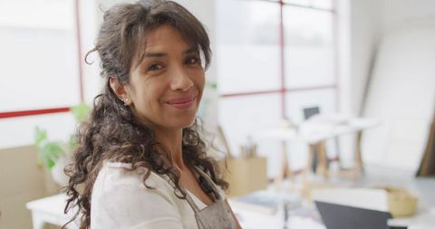 Confident biracial woman smiling in creative workspace with copy space