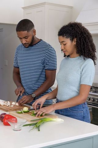 Couple Collaborating in Kitchen While Preparing Fresh Vegetables