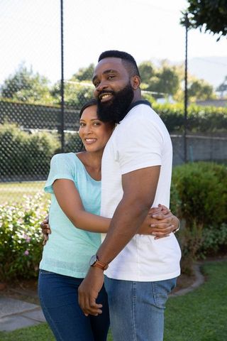 Diverse Couple Embracing in Sunny Outdoor Setting