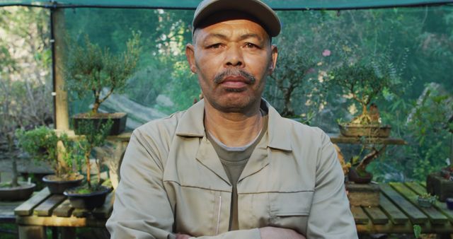 Serious Male Gardener in Greenhouse with Small Trees - Download Free Stock Images Pikwizard.com