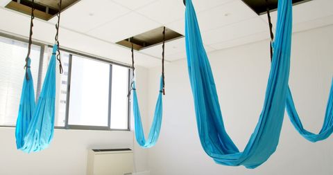 Aerial yoga hammocks hanging in bright studio