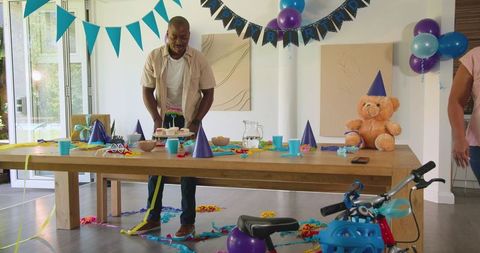 Man Preparing Birthday Party Table at Home with Decorations