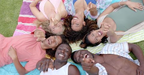 Joyful Friends Relaxing on Blankets at Park