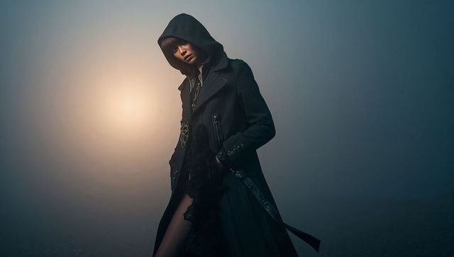 Posing Hooded Fashion Portrait Featuring Female Model Wearing Long Coat and Pendant