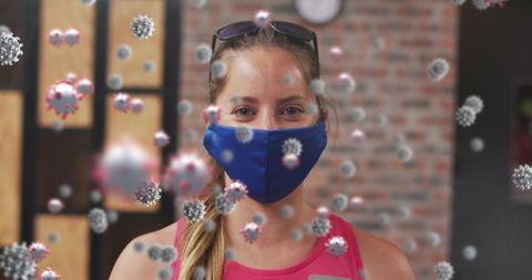 Fit woman in gym wearing mask with covid-19 illustrations