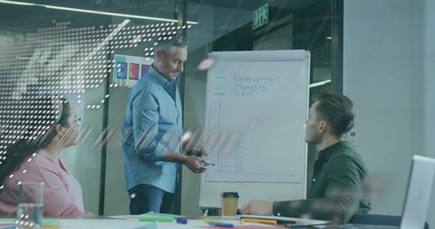 Presenting growth strategy on flipchart during collaborative team meeting in modern office